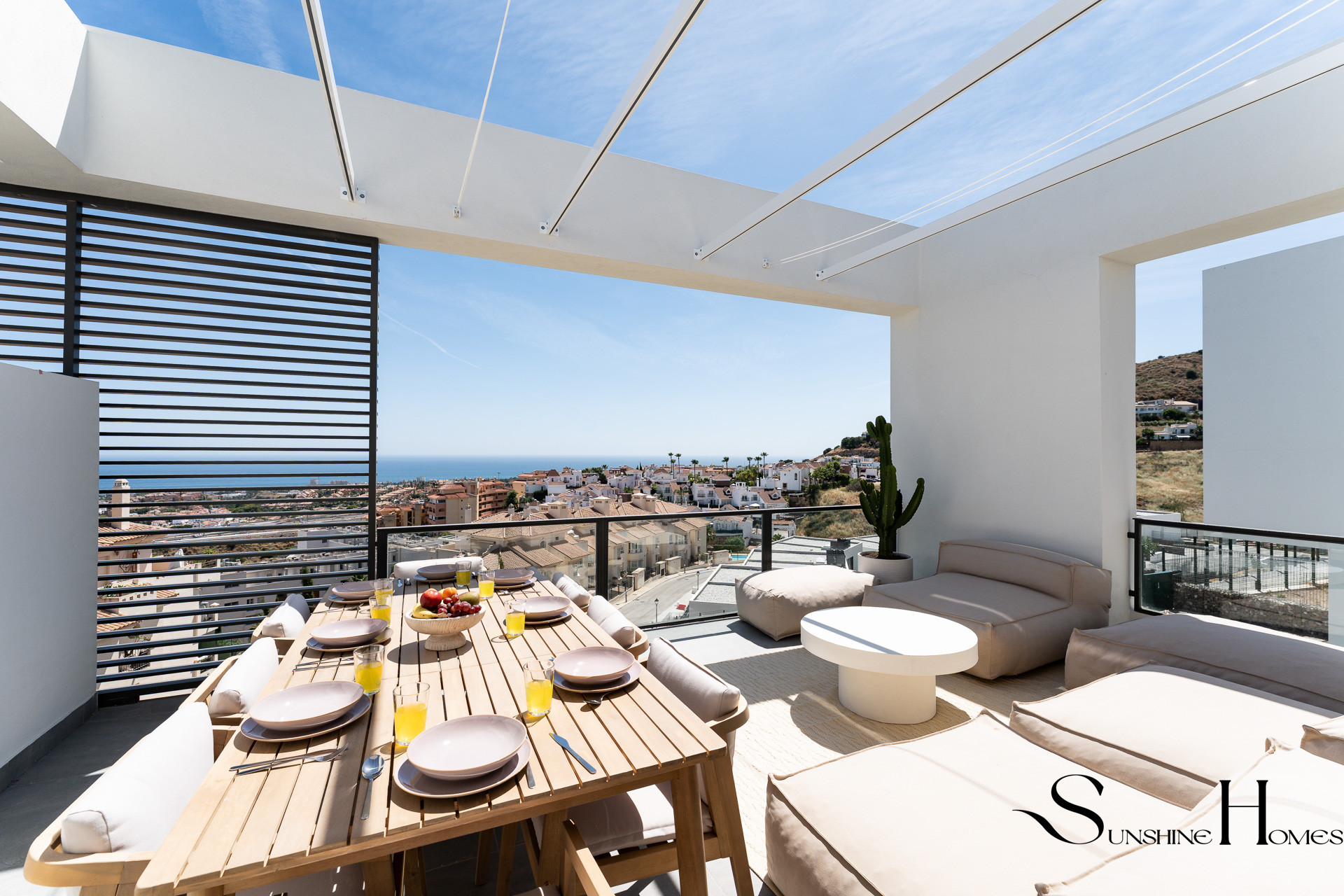 Covered terrace with dining table overlooking the sea
